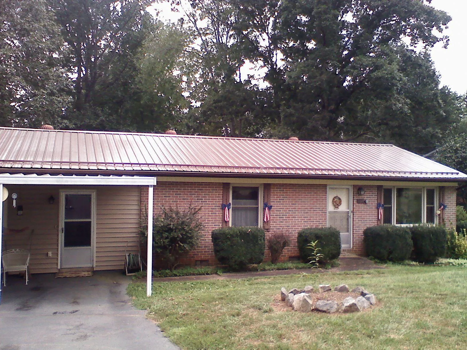 Bronze metal roof and carport on a brick ranch home — Roof Repair work by our crew in Mandeville