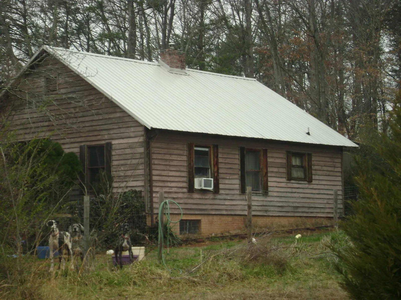 White metal roof on an old wood sided farmhouse, from a Metal Roof Installation job in Mandeville